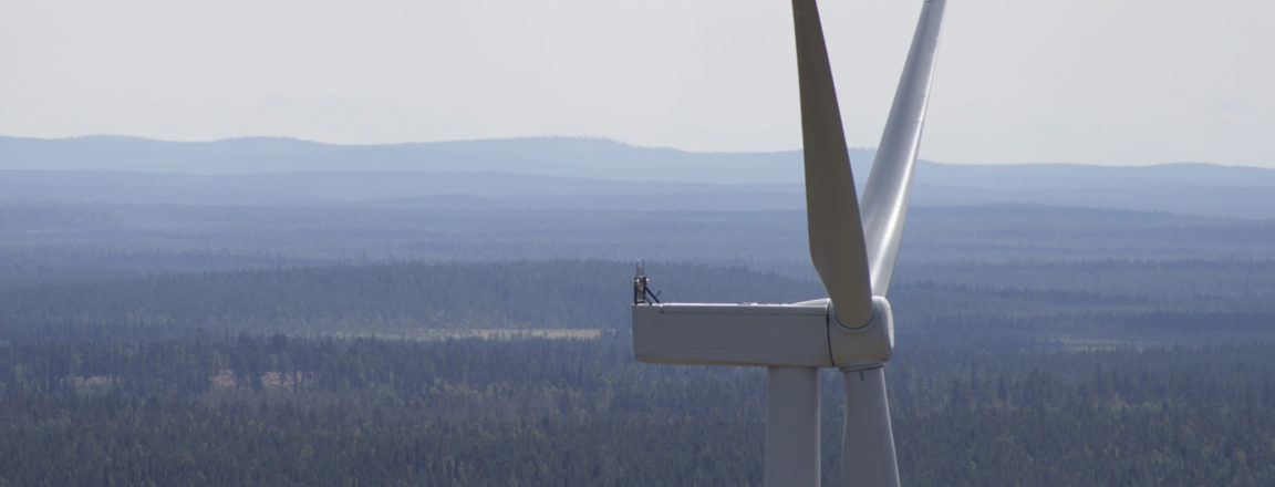 Tuulivoimala. Takana näkyy suomalaista metsää ja tunturimaisemaa. Kuva: Suomen Tuulivoimayhdistys ry.