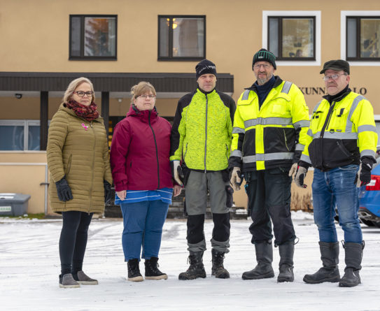 Kaksi naista ja kolme miestä seisovat Taivalkosken kunnantalon edessä.