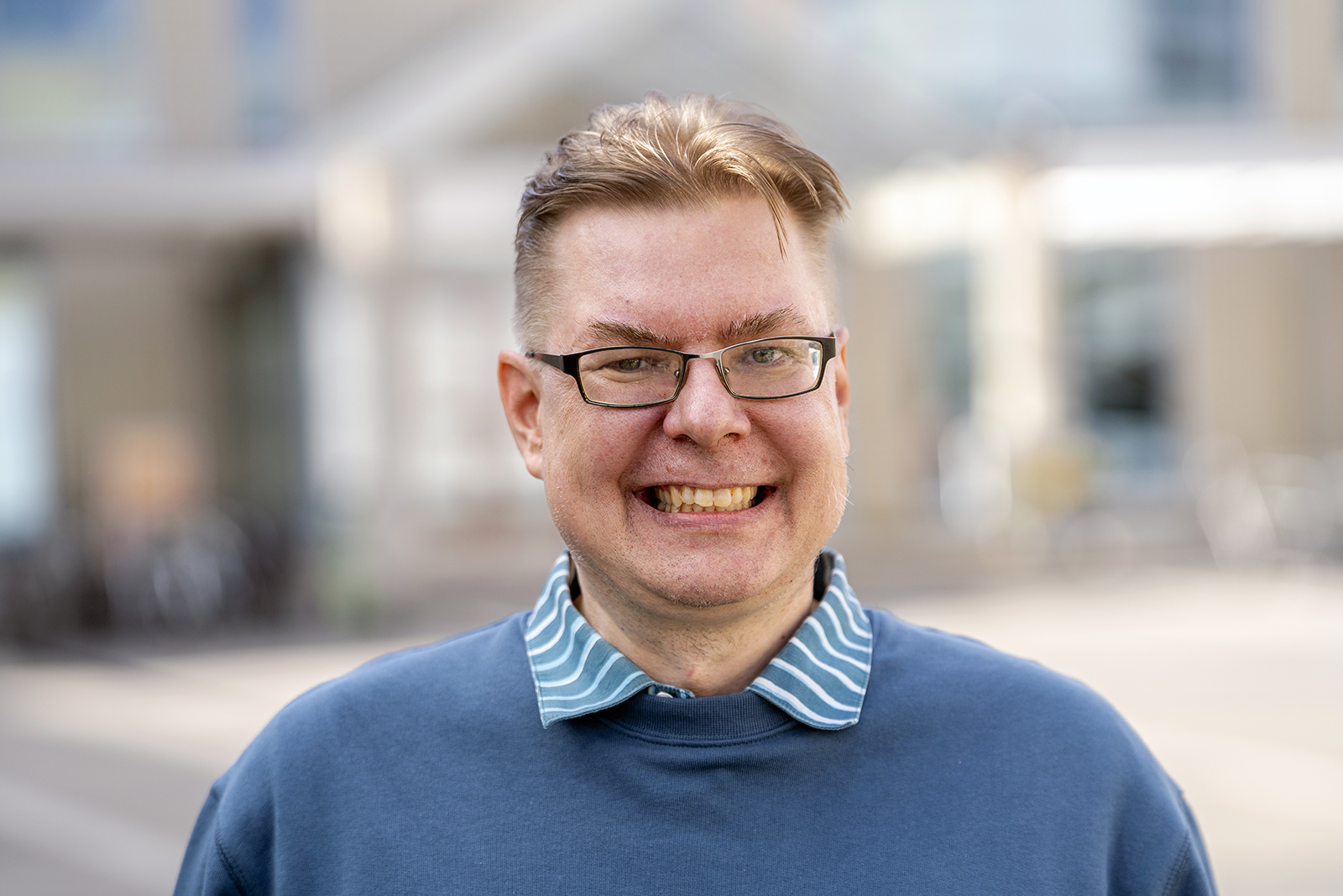 Kalle Nuortimo pictured in front of the University of Oulu wearing a blue shirt.