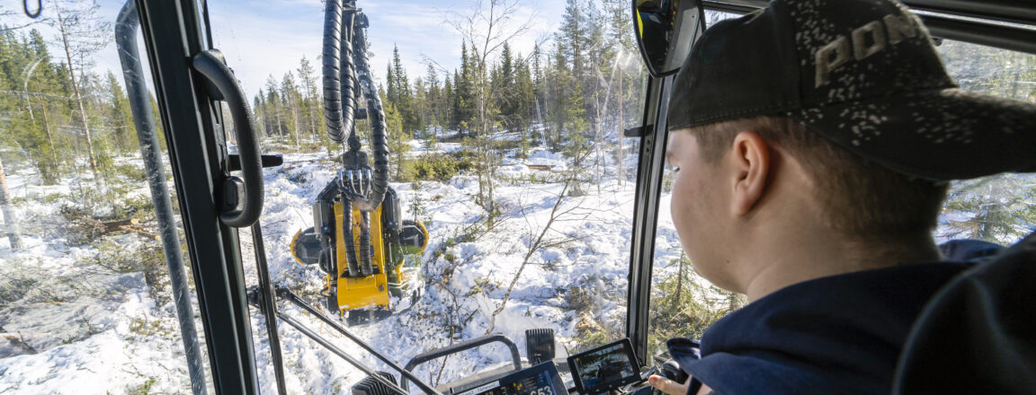 OSAOn metsäalan opiskelija kuvattuna metsäkoneen ohjaamossa.