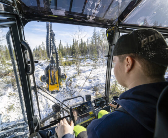 OSAOn metsäalan opiskelija kuvattuna metsäkoneen ohjaamossa.